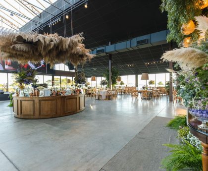 Stylish indoor wedding venue with rustic decor and floral elegance, perfect for a spacious celebration. — Bathroom Wall Panel
